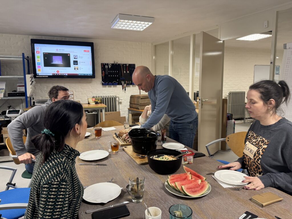 IDbike team sharing a meal with homemade bread, watermelon, and a hot dish in the office break area.